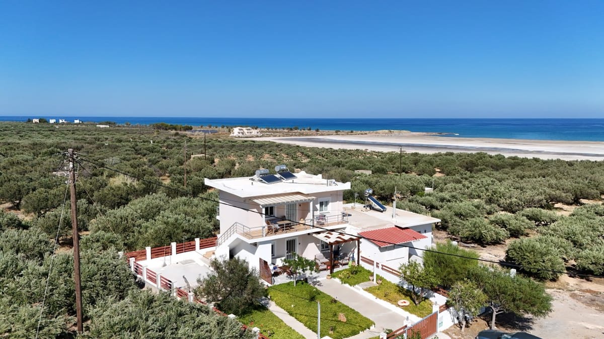 The wide sandy bay below the house, seen across the olive groves